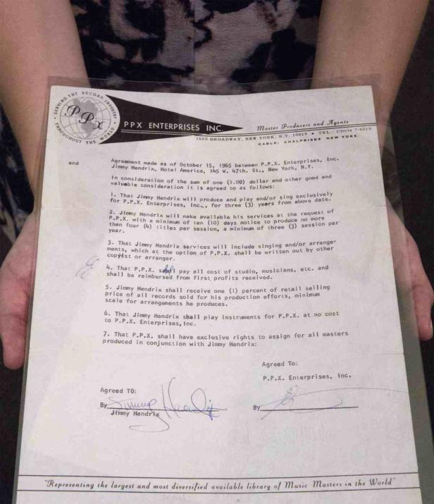A Sotheby's employee shows a contract between Jimi