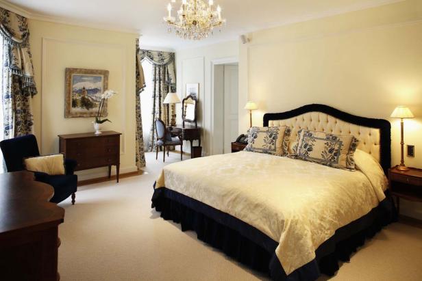 Ein Schlafzimmer mit einem großen Bett, einem Schreibtisch und einem Kristalllüster.