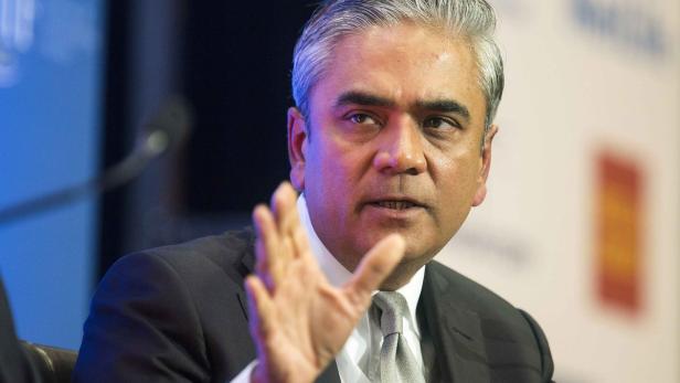 Ein Mann mit grau meliertem Haar gestikuliert während einer Präsentation.