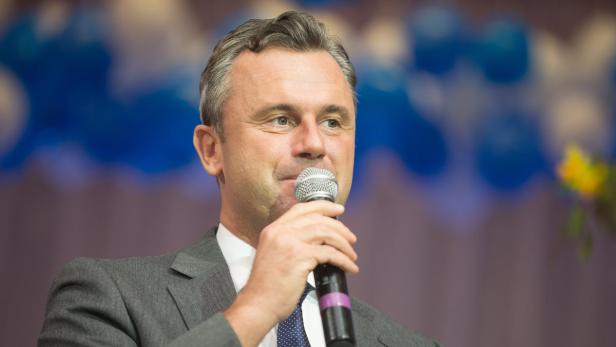 Ein Mann im Anzug spricht in ein Mikrofon.