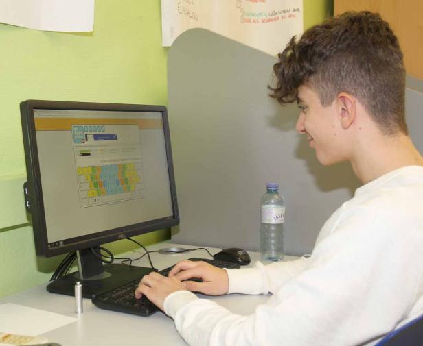 Ein junger Mann tippt auf einer Computertastatur.