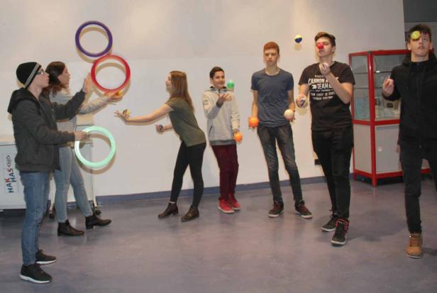 Eine Gruppe von Jugendlichen jongliert mit Bällen und Ringen.