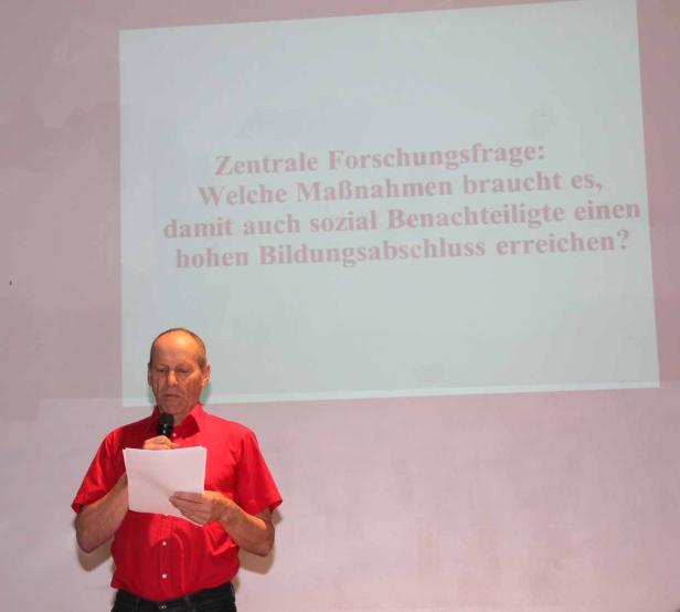 Ein Mann präsentiert eine Folie mit der Frage, welche Maßnahmen sozial Benachteiligten zu einem hohen Bildungsabschluss verhelfen.
