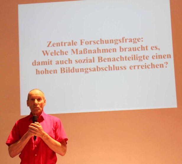 Ein Mann präsentiert eine Folie mit der Frage: Welche Maßnahmen braucht es, damit auch sozial Benachteiligte einen hohen Bildungsabschluss erreichen?.