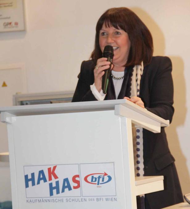 Eine Frau spricht am Rednerpult mit den Logos von HAK/HAS und BFI Wien.
