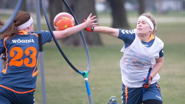 Zwei Quidditch-Spielerinnen kämpfen um den Ball während eines Spiels.