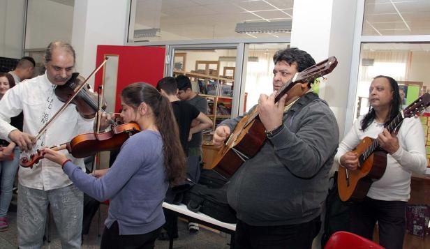Eine Gruppe von Musikern spielt Geige und Gitarre in einem Raum.