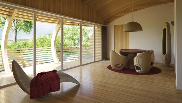 Ein helles Zimmer mit Holzfußboden, einem Liegestuhl und einem Esstisch mit ungewöhnlichen Stühlen.