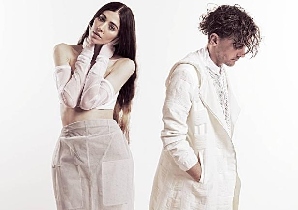 Eine Frau und ein Mann posieren in weißer Kleidung vor einem weißen Hintergrund.