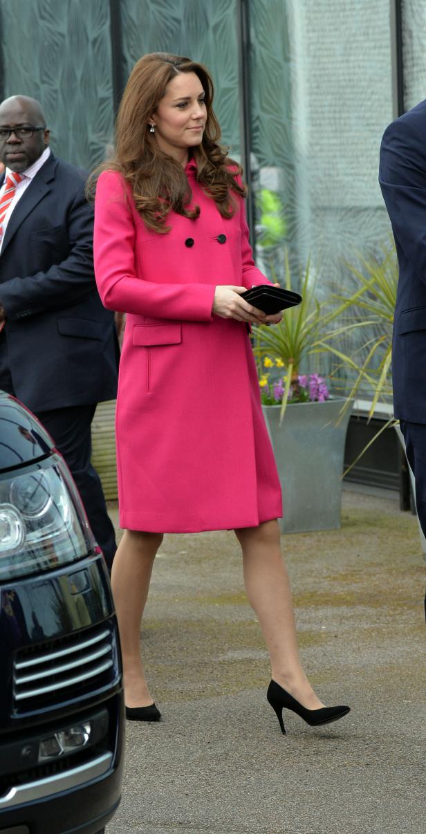 Kate Middleton trägt einen pinkfarbenen Mantel und schwarze Schuhe.