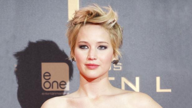 Porträt von Jennifer Lawrence mit blonden, hochgesteckten Haaren und auffälligen Ohrringen.