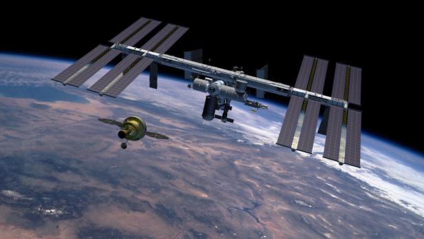 Die Internationale Raumstation ISS und ein angedocktes Raumschiff über der Erde.