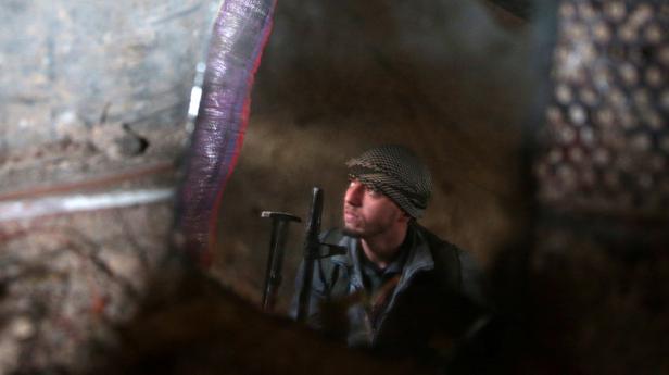 A rebel fighter of Jaysh al-Islam is reflected in