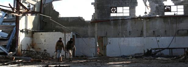 Free Syrian Army fighters carry their weapons as t