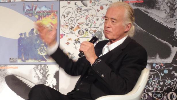 Jimmy Page spricht vor dem Hintergrund von Led Zeppelin-Albumcovern.