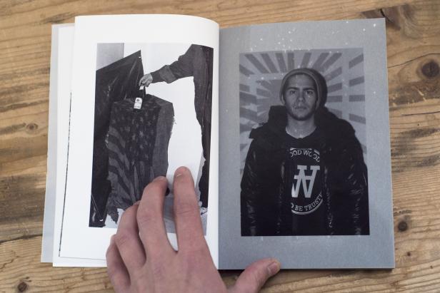 Ein aufgeschlagenes Buch mit Schwarz-Weiß-Fotografien auf einem Holztisch.