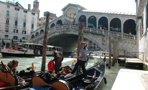 Gondeln und andere Boote auf dem Canal Grande in Venedig vor der Rialtobrücke.