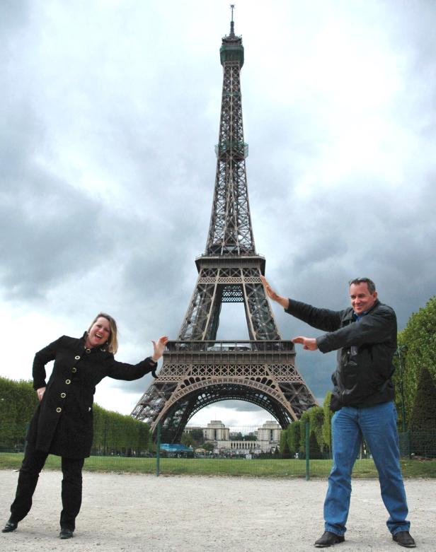Ein Mann und eine Frau posieren vor dem Eiffelturm in Paris.