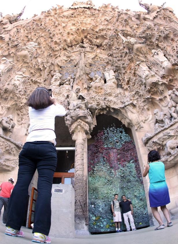 Besucher fotografieren die Fassade der Sagrada Familia in Barcelona.
