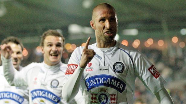 Ein Fußballspieler in weißem Trikot jubelt mit erhobenem Zeigefinger.