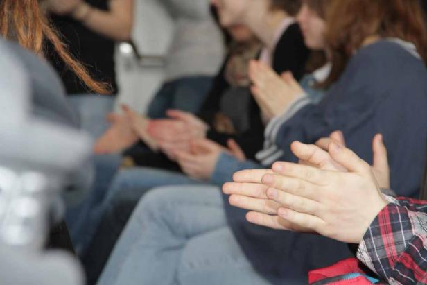 Eine Gruppe von Menschen klatscht Beifall.