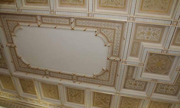 Eine kunstvoll verzierte Decke mit goldenen Akzenten und floralen Mustern.