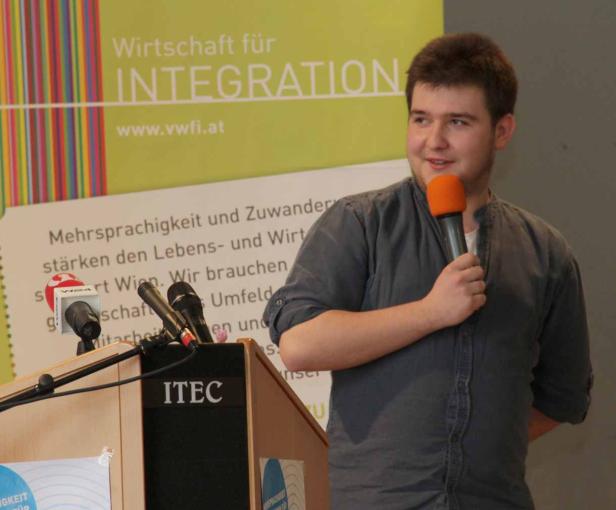 Ein junger Mann spricht bei einer Veranstaltung zum Thema Integration.