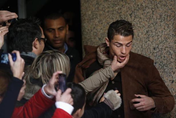 Cristiano Ronaldo wird von Fans umringt und berührt.