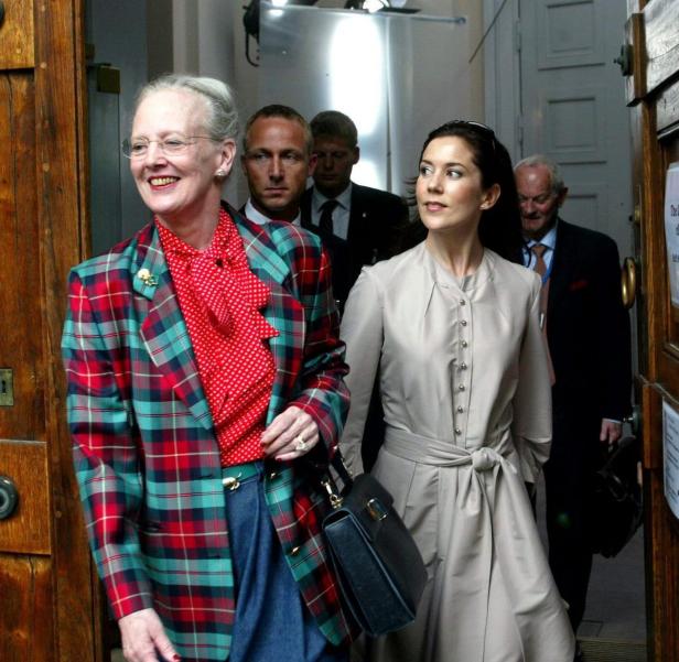 Königin Margrethe II. und Kronprinzessin Mary verlassen ein Gebäude.
