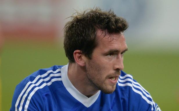 Ein Fußballspieler in einem blauen Trikot mit weißen Streifen.