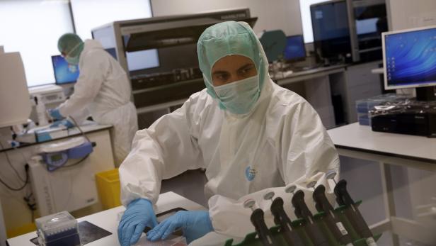 Ein Wissenschaftler in Schutzkleidung arbeitet in einem Labor.