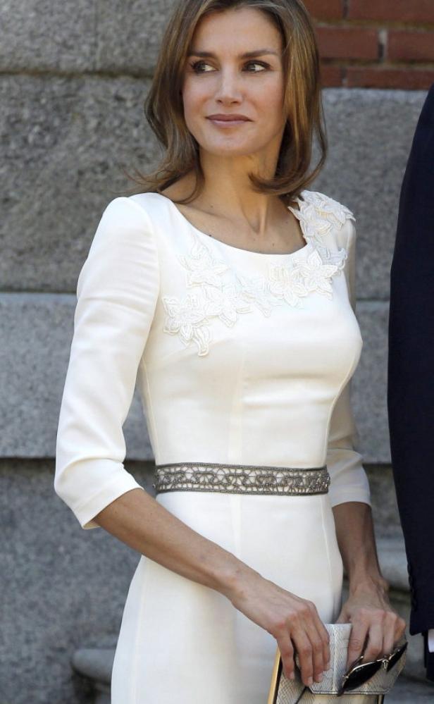Königin Letizia trägt ein weißes Kleid mit floralen Details und silbernem Gürtel.