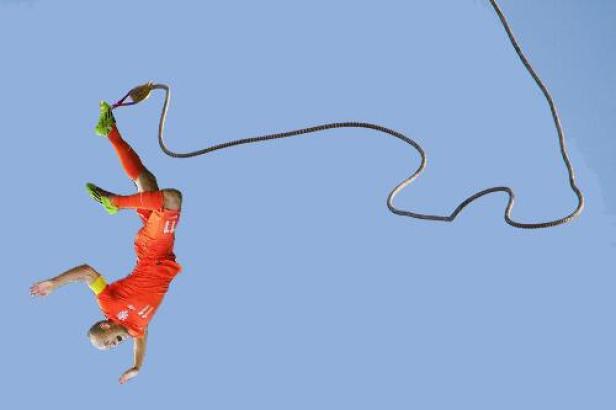 Ein Fußballspieler springt mit einem Bungee-Seil in den Himmel.