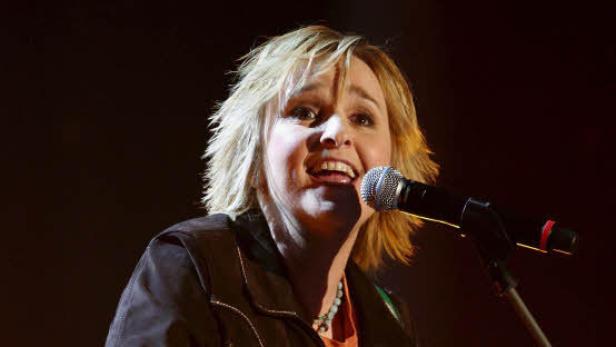 Melissa Etheridge singt in ein Mikrofon.