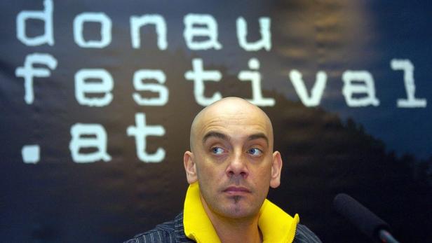Ein Mann vor einem Banner des Donaufestivals.