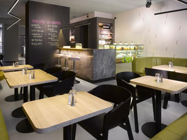 Innenansicht eines Tapas-Restaurants mit Tischen, Stühlen und einer Bar.