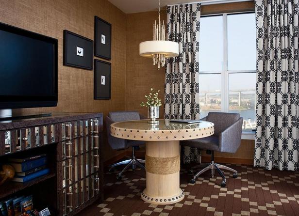 Ein Zimmer mit einem runden Tisch, zwei Stühlen und einem Fenster mit Blick auf eine Brücke.