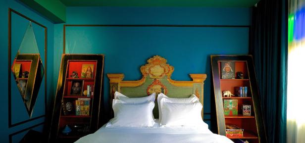 Ein Schlafzimmer mit einem verzierten Bett und zwei Bücherregalen an den Seiten.