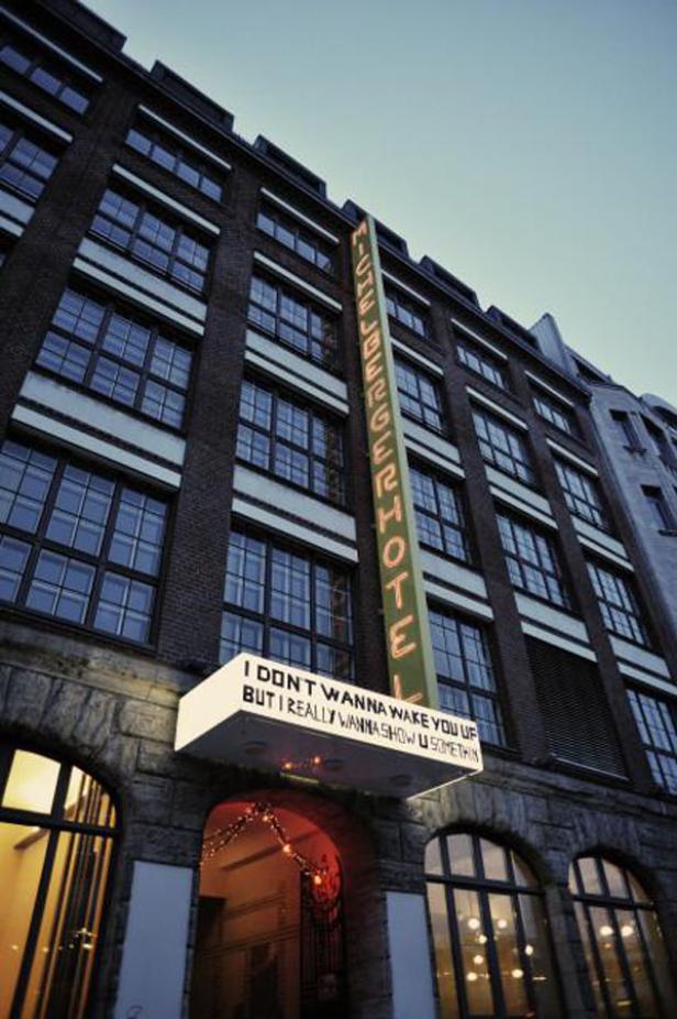 Das Michelberger Hotel in Berlin mit einem leuchtenden Schild über dem Eingang.