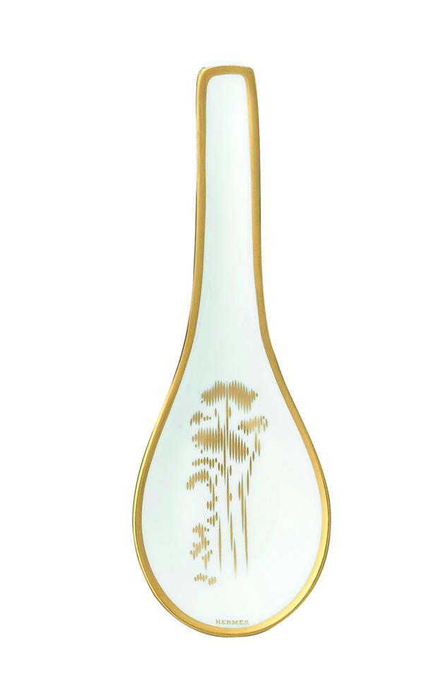 Ein weißer Porzellan-Löffelhalter von Hermès mit goldenen Verzierungen.