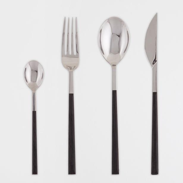 Ein Besteckset mit Messer, Gabel, großem Löffel und kleinem Löffel auf einem weißen Hintergrund.