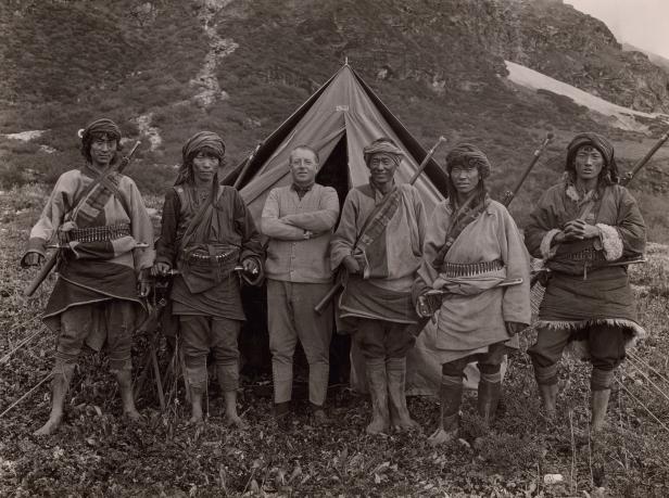 Eine Gruppe von sechs Personen posiert vor einem Zelt in einer Berglandschaft.