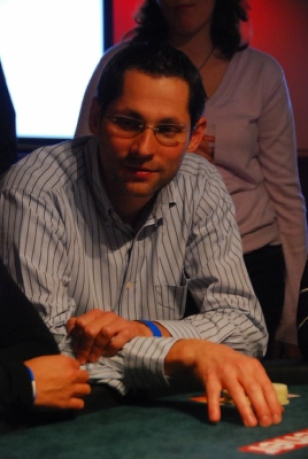 Ein Mann mit Brille spielt Poker.