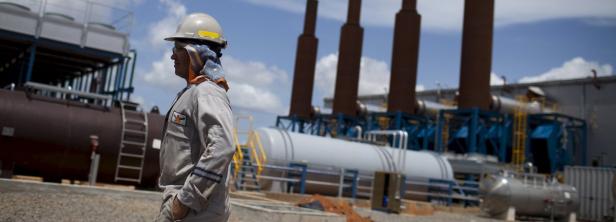File photo of an oil worker walking past an oil in Venezuela erhöht erstmals seit 20 Jahren Benzinpreis