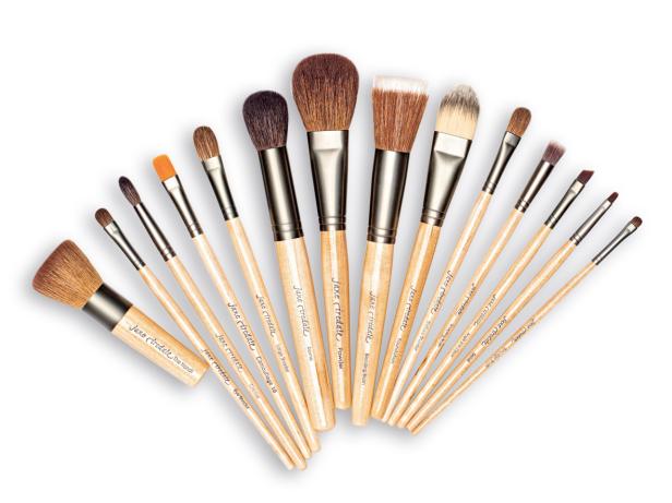 Eine Sammlung von Make-up-Pinseln der Marke Jane Iredale, aufgereiht auf einem weißen Hintergrund.