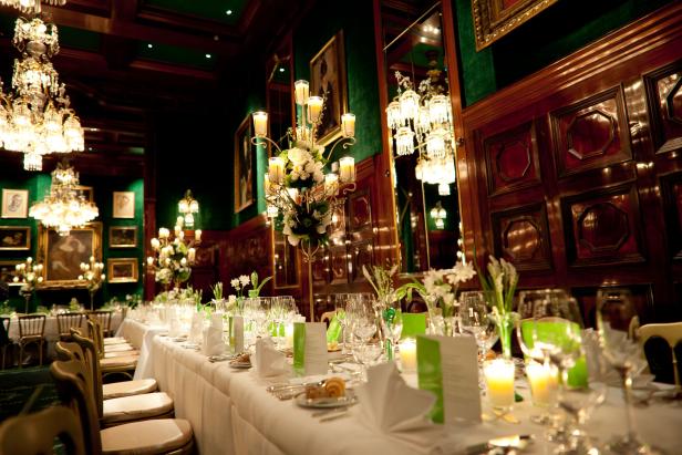 Ein festlich gedeckter Tisch in einem eleganten Speisesaal mit Kronleuchtern.