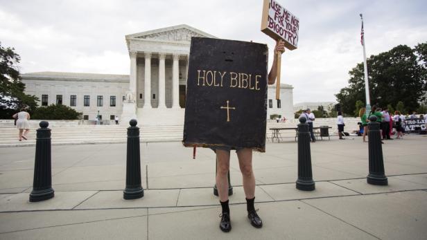 Eine Person in einem „Heilige Bibel“-Kostüm demonstriert vor dem Supreme Court.