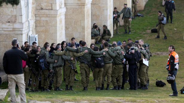 Eine Gruppe israelischer Soldaten steht mit verschränkten Armen auf einer Wiese.