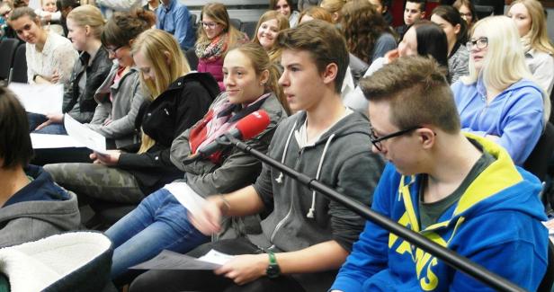 Ein junges Publikum sitzt während einer Veranstaltung in einem Raum.