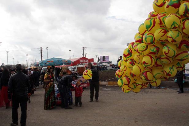 Auf einem Markt kaufen Menschen gelbe Luftballons.